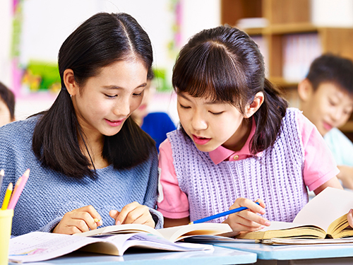Photo of two students attending an English tuition workshop
